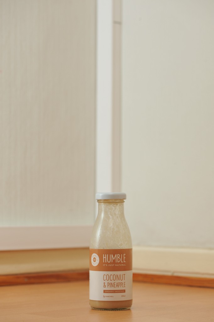 Tyhjä, puhdistamaton Humble-smoothien 0,25 litran kirkas lasipurkki puunvärisellä lattialla.