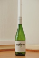 Rypäleistä käymisteitse valmistetun miedon alkoholijuoman Sangre de Toro 5,5:n tyhjä vihreä 0,75 litran lasipullo puunvärisellä lattialla.
